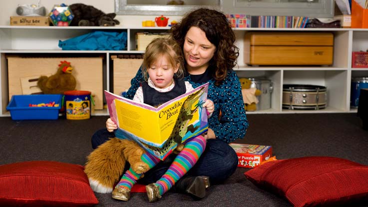 Mother and daughter sitting on the floor reading