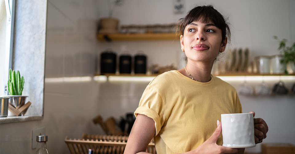 young woman with a coffee cup wearing a yellow t shirt