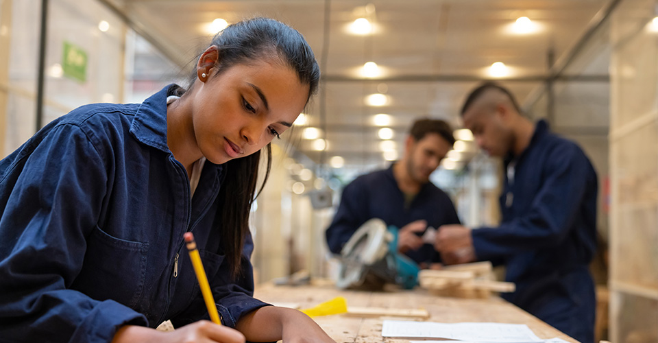 a young woman working on a woodworking bench