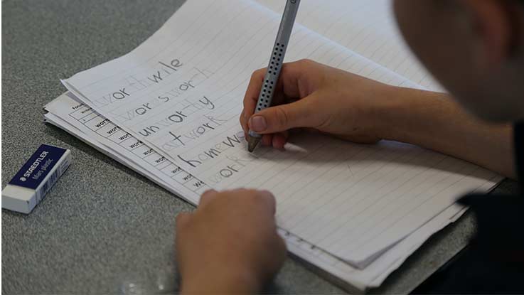 Student writing on paper