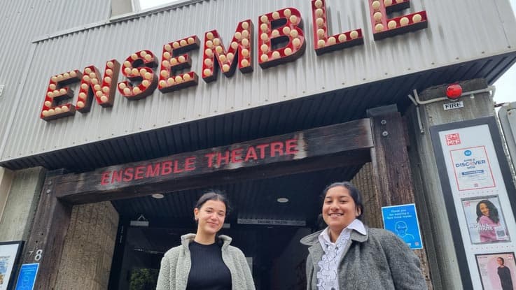 two females standing outside of Ensemble theatre enterance