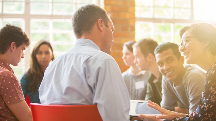 A group of people seating together and brainstorming
