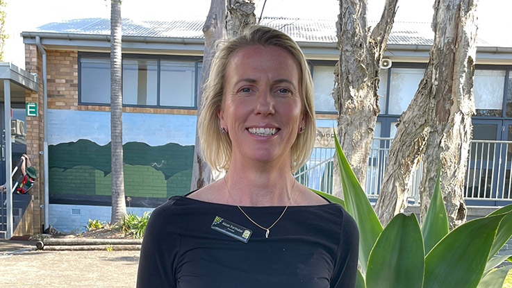 a woman with short blond hair wearing a black top