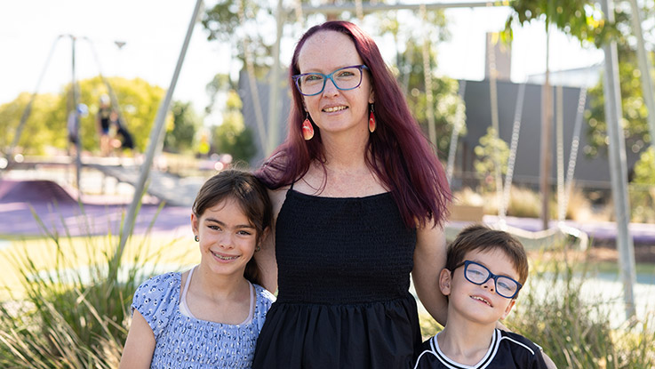 a mother posing with her young daughter and son