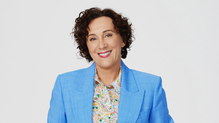 an image of a women with medium brown curly hair and wearing a blue suit