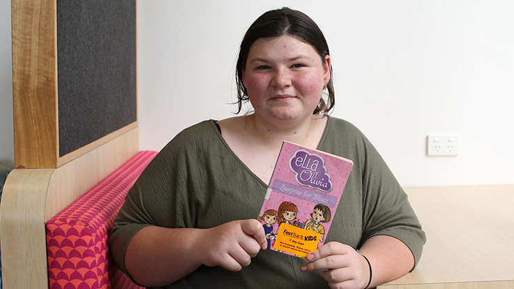  a young school girl holding her favourite book