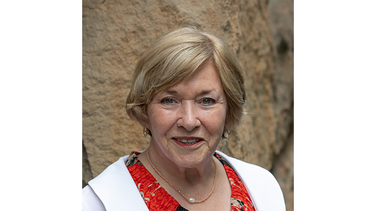 a woman smiling wearing a white jacket and red top