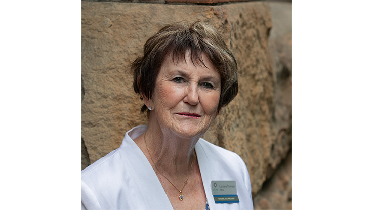 a woman smiling wearing a white jacket