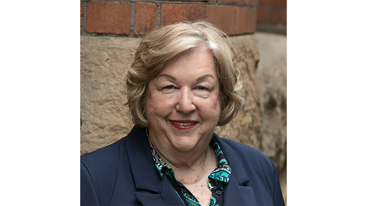 a woman smiling wearing a navy jacket