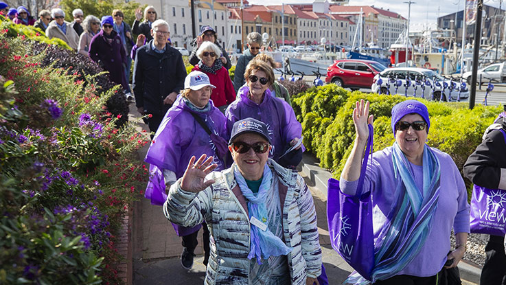 a group of ladies walking together wearing purple