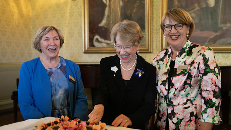 governor general with view ladies celebrating 65 years and cutting into a cake